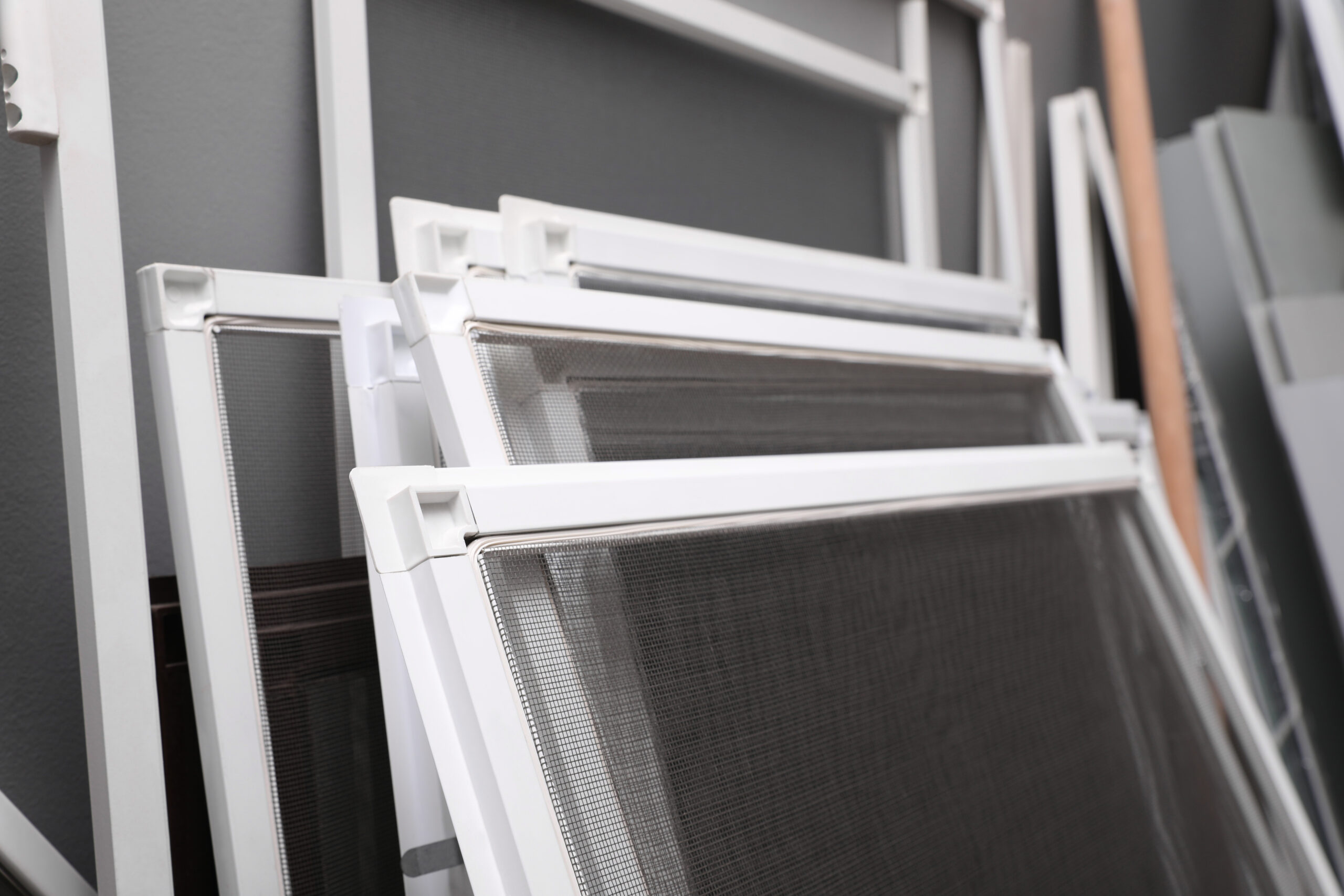 Mosquito window screens near grey wall, closeup