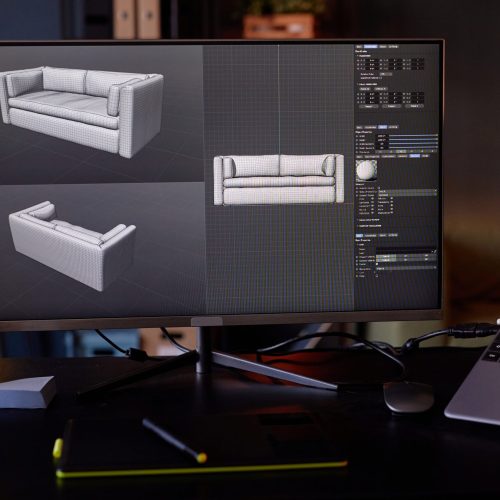 Designing 3D model of couch in stylish workspace, featuring advanced technology. Display screens show various angles of the model while coffee cups sit on table, creating realistic environment